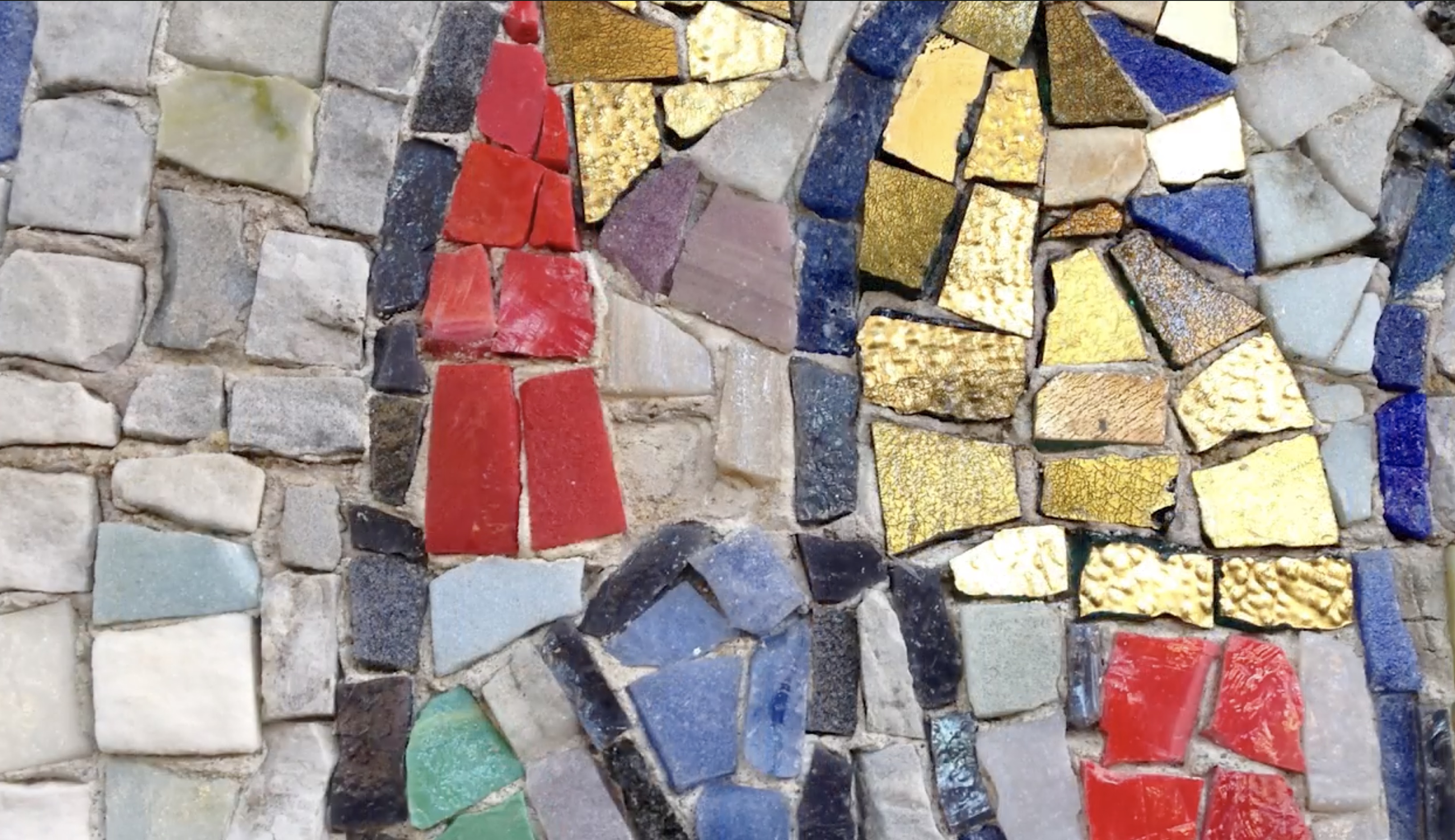 Close up of red, blue, gold, green, black, gray and white mosiac tiles 