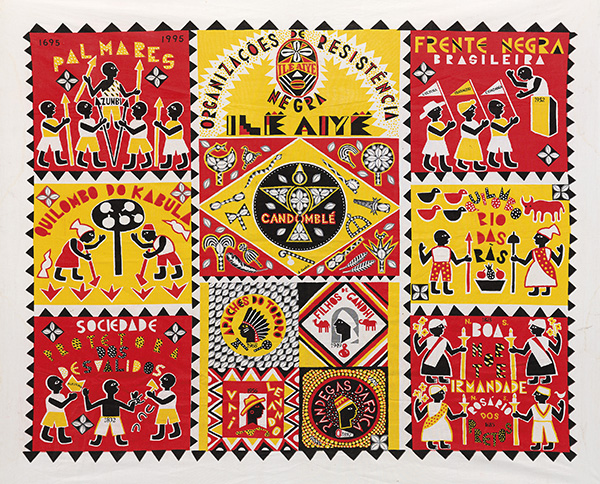 This is a photograph of a brightly colored quilt. The predominant colors are red, yellow, black and white