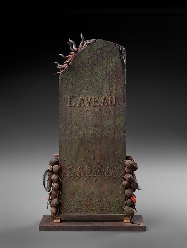 This is a photograph of an upright stone tablet. The word Laveau is inscrbed in the stone