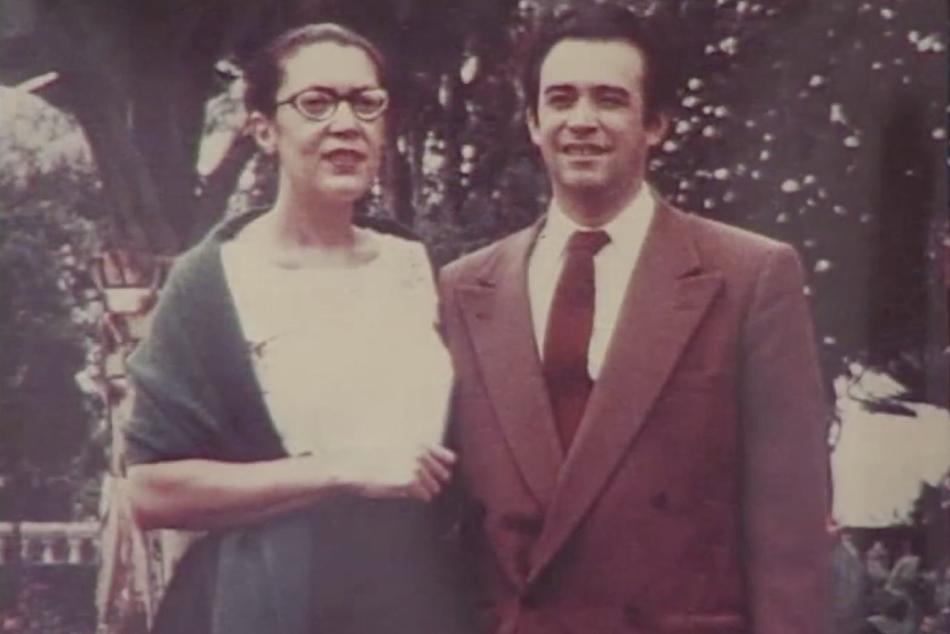 A man and a woman standing side-by-side and smiling.