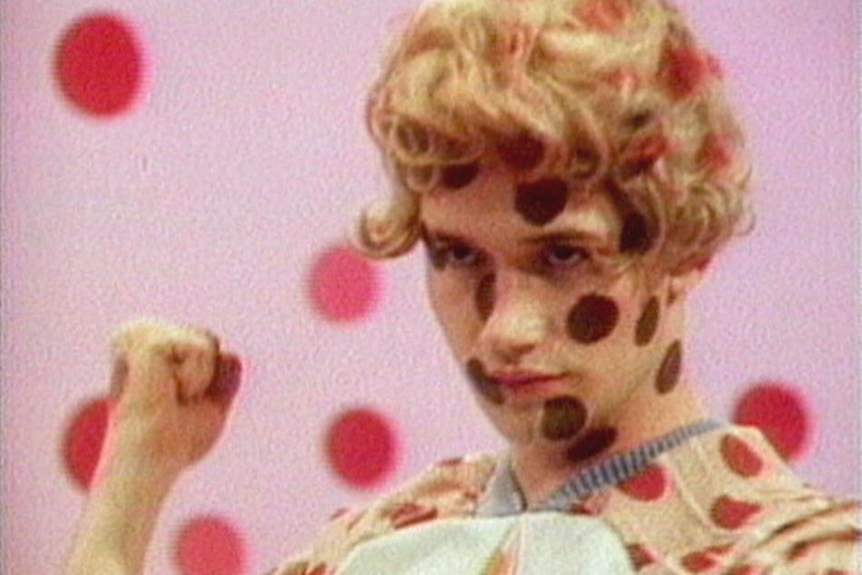 A person with polka dots on their face, outfit, and in the background.