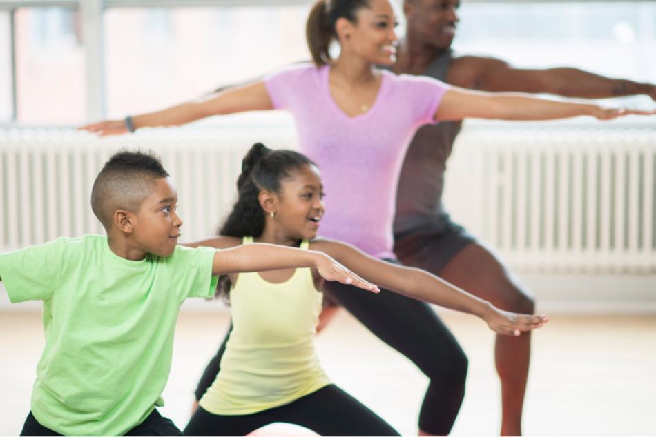 Adults and children doing yoga poses together.