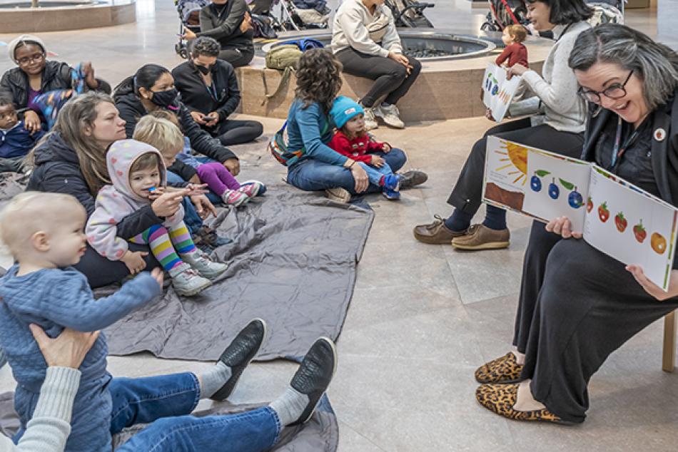 A group of visitors enjoy Storytime in the National Gallery's East Building.