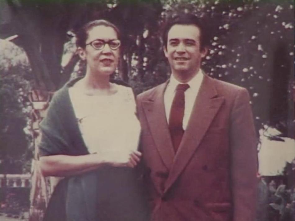 A man and a woman standing side-by-side and smiling.