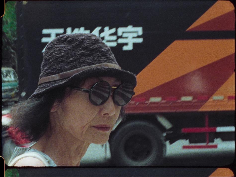 A woman wearing a hat with a circular brim and round sunglasses.