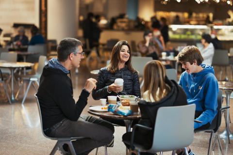 Visitors sitting at a table enjoying food and drinks in the National Gallery's Cascade Café.
