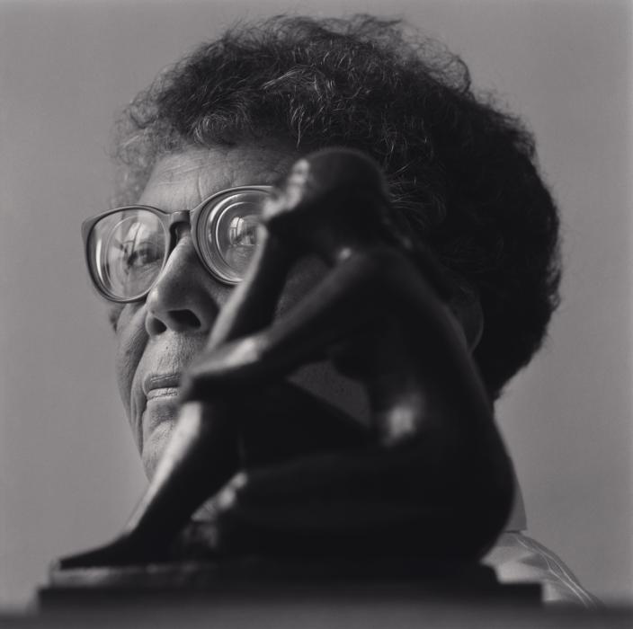 Elizabeth Catlett poses behind her sculpture