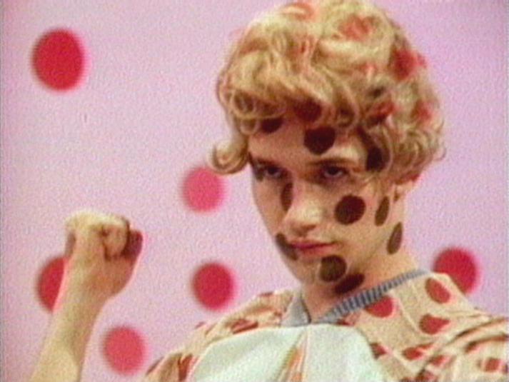 A person with polka dots on their face, outfit, and in the background.