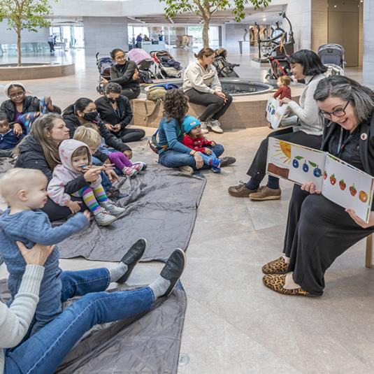 A group of visitors enjoy Storytime in the National Gallery's East Building.