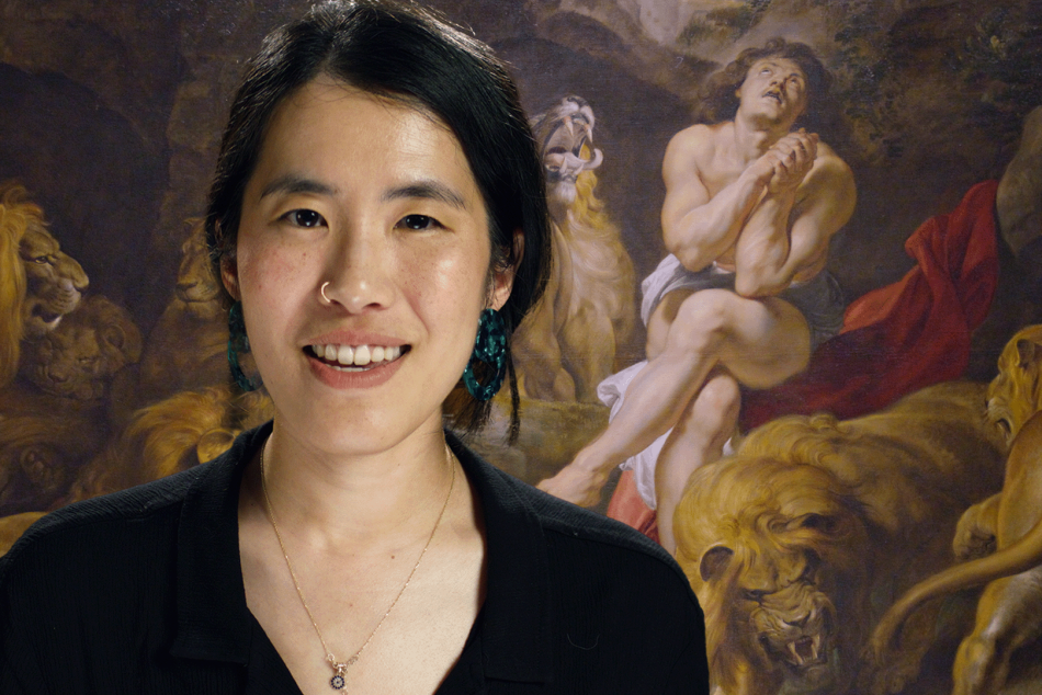 A photograph of a woman in front of Peter Paul Rubens' Daniel in the Den of Lions
