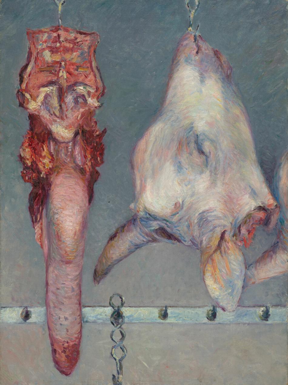 Pieces of meat hang in a butchers shop. One of the pieces is the head of a cow.