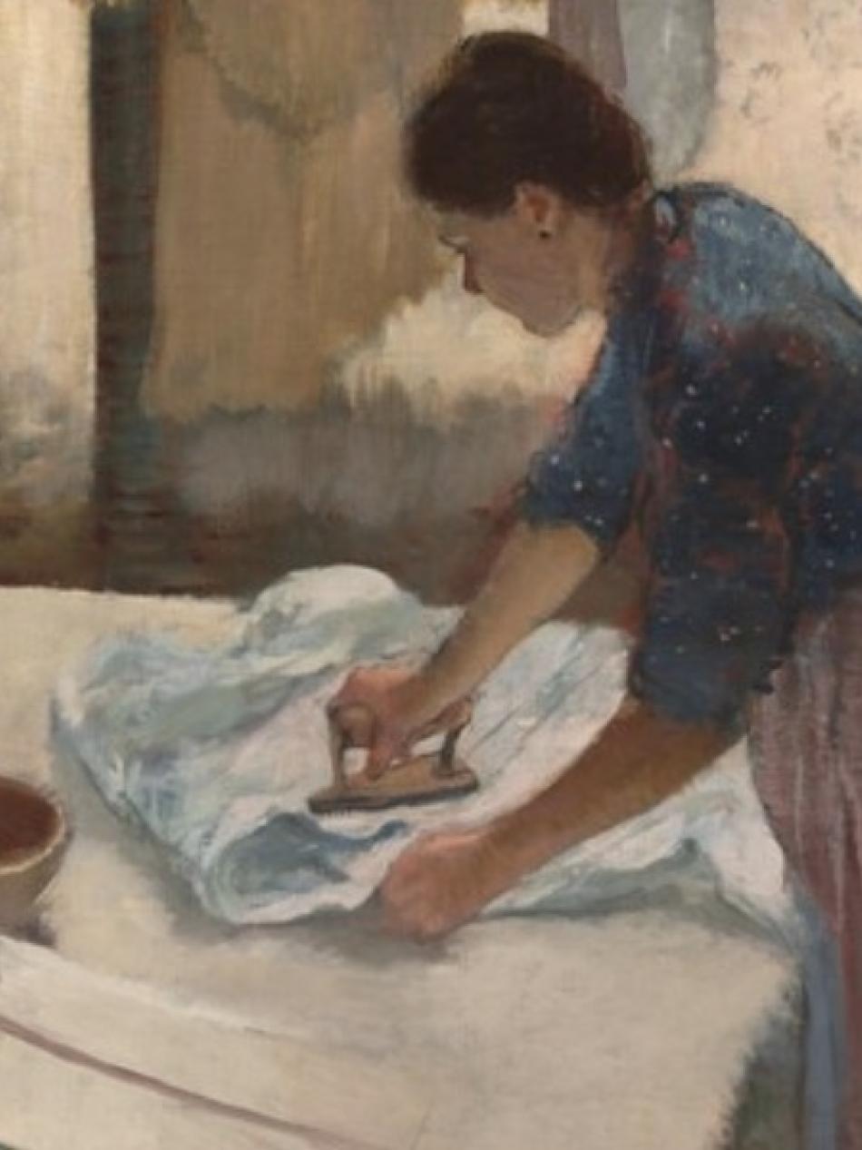 A woman is ironing fabric in front of windows.