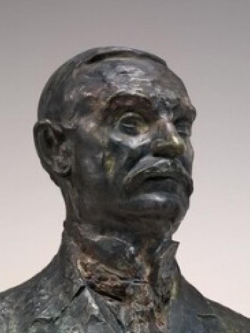 This is a bronze sculpture of a man's upper body and head. He is looking to our right and he has a mustache.