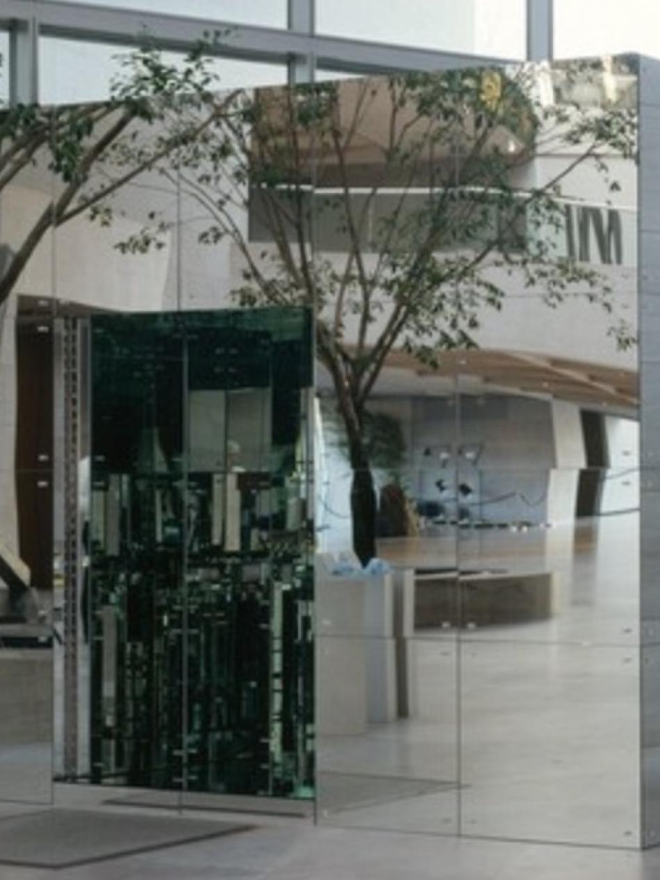 This is a cube with a mirrored exterior. It is the East Building Atrium. It's large enough to walk inside and it has a door.
