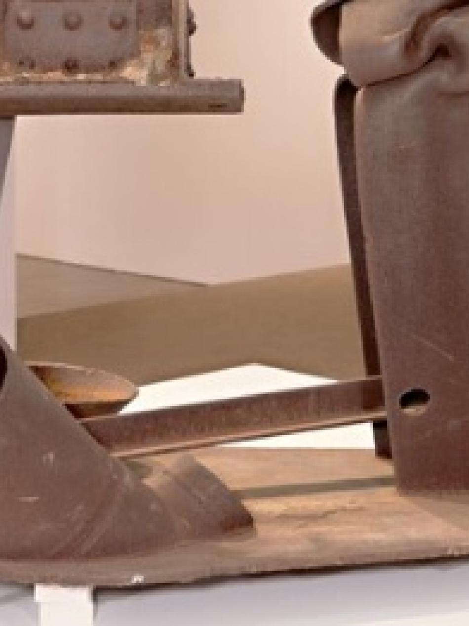 This is an abstract metal sculpture on a white base.