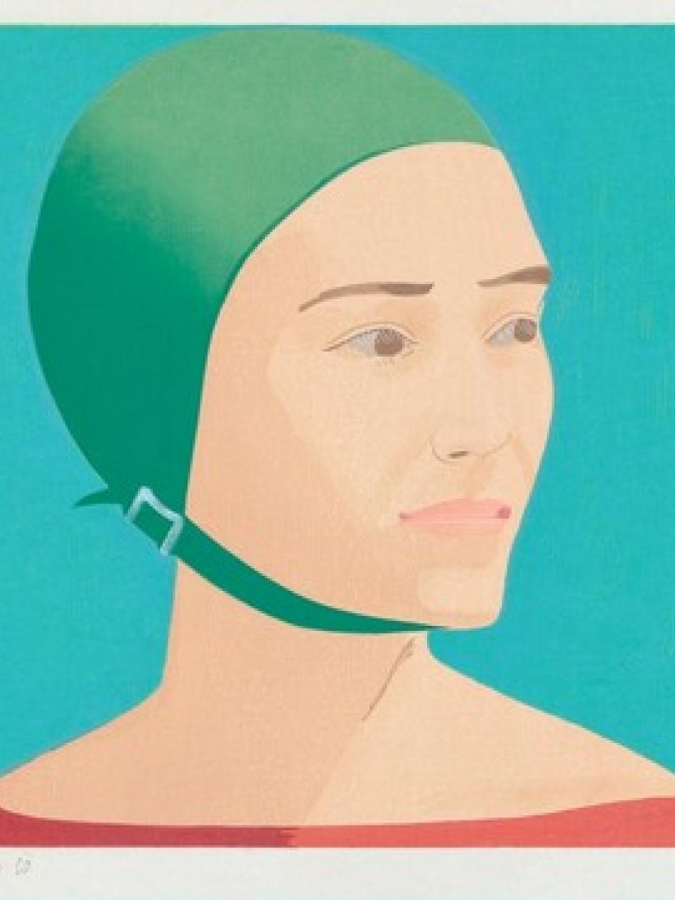 A woman looks to our right. She is wearing a green swim cap.