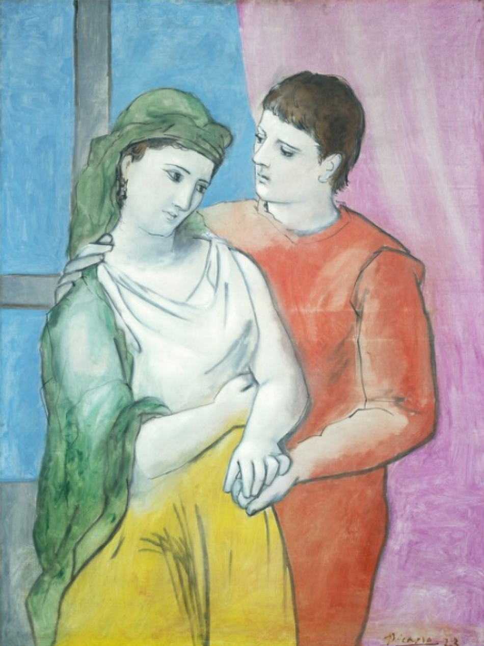Two people stand close together, one behind the other and hold hands.