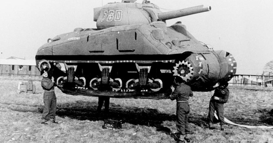 Four Allied soldiers lift one of the dummy tanks used in Operation Viersen